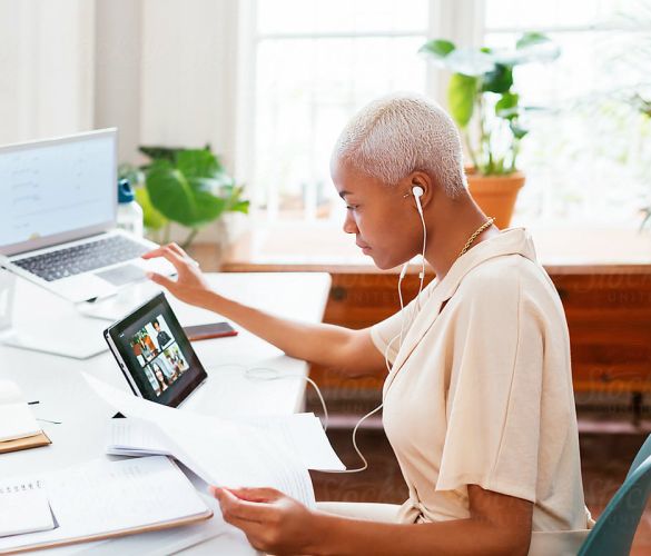 Woman working remotely on different devices and in zoom and hubspot at the same time