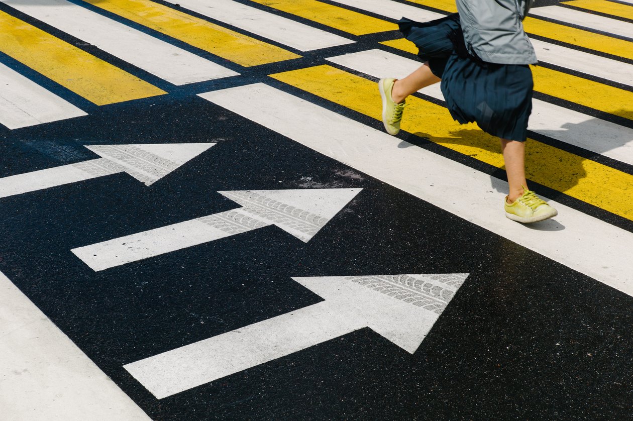 A woman running over a colored pedestrian crossing