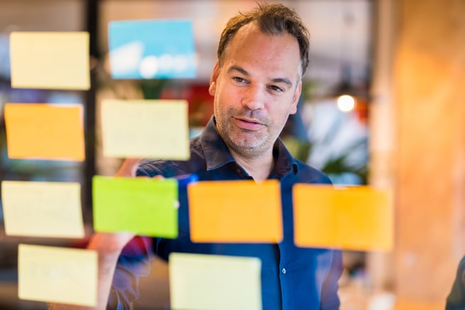 A strategical thinker who is brainstorming using post-its