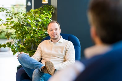 A manly consultant who is looking friendly while chatting to a client