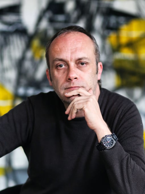 A man posing, looking seriously in the camera