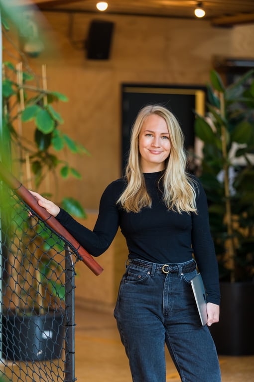 annika bjorkholm of swipeguide who is posing friendly while holding a laptop