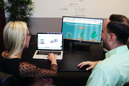 Business meeting wherein a women is explaining HubSpot using her computer