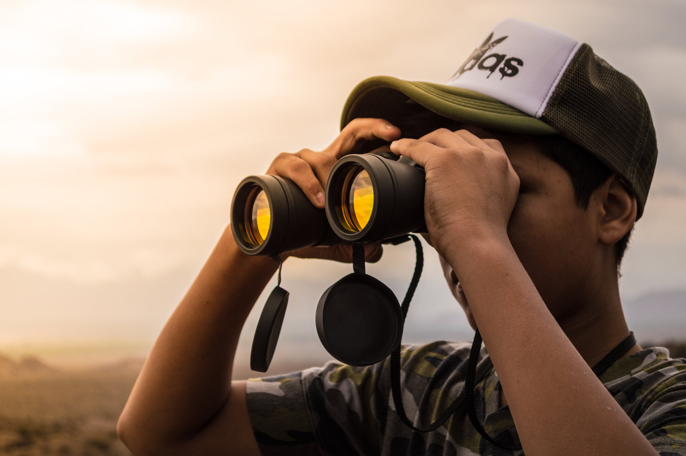 man using his binoculars to look in the distance